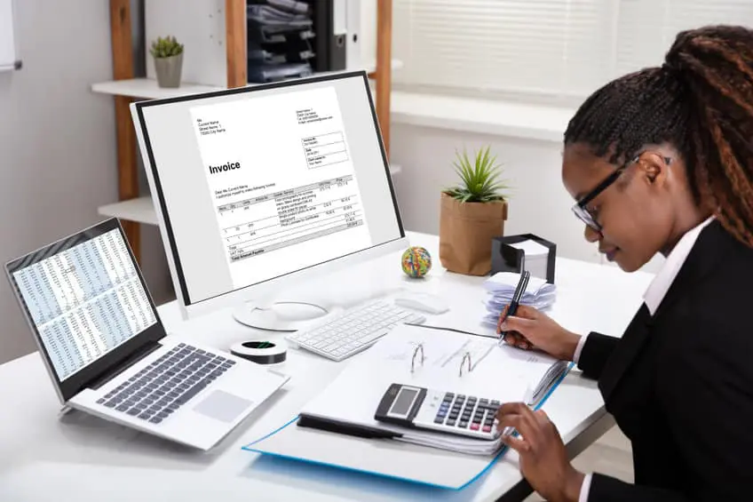 Businesswoman Using Calculator Calculating Invoice
